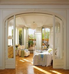 an open door leading to a bedroom with white walls and wood flooring on the other side