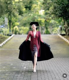 a woman in a graduation gown is walking down the street