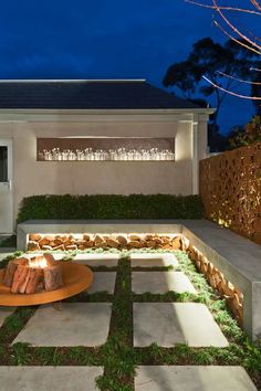 an outdoor fire pit in front of a house at night