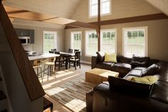 a living room filled with furniture next to a kitchen and breakfast nook area on top of a hard wood floor