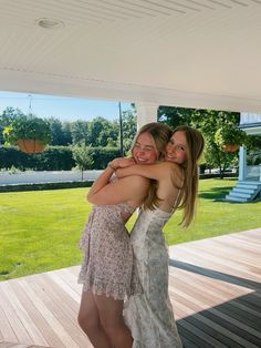 two women hugging each other on a porch