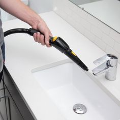 a person using a hair dryer on top of a sink