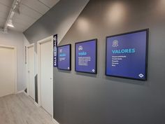 an office hallway with three blue signs on the wall