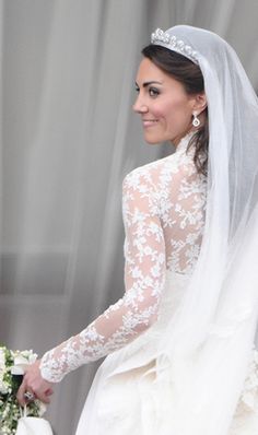 the bride smiles as she walks down the aisle in her wedding dress and tiara