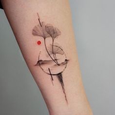 a woman's arm with a tattoo on it and a red dot in the middle