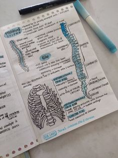 a notebook with a diagram of the human body on it and a pen next to it