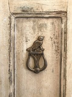 an old door handle with a bird on it