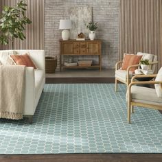 a living room with two chairs and a rug on the floor in front of a brick wall