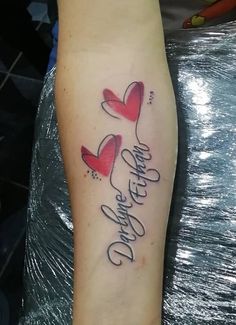 a tattoo with two hearts and the words love is in the air