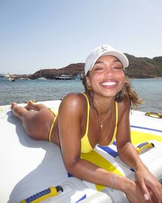 a woman in a yellow bathing suit sitting on a boat