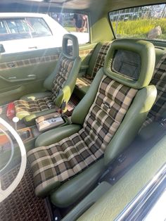 the interior of a car with green leather and plaid upholstered seat covers on it