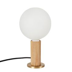 a white ball sitting on top of a wooden stand next to a light brown base