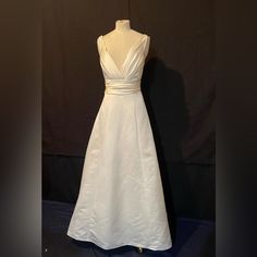 a white dress on display in front of a black backdrop