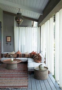 a living room with a couch, coffee table and rugs on the wooden floor