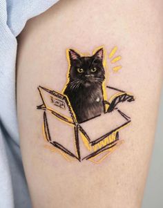 a black cat in a box tattoo on the left side of the right arm and shoulder