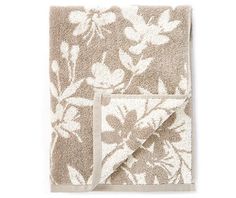 a towel with white flowers on it and a brown border around the edges is folded