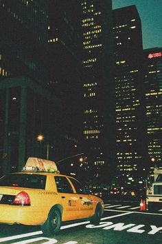 a taxi cab is stopped at an intersection in the city