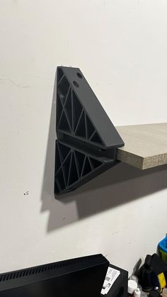 a shelf that has some sort of triangular object on it's back end, hanging from the wall