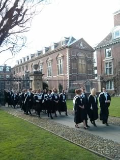 a group of people in graduation gowns walking down the street