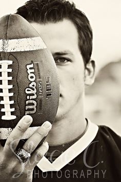 black and white photograph of a man holding a football in front of his face with the words i love you on it