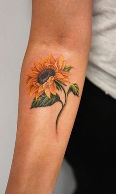 a woman's arm with a sunflower tattoo on it