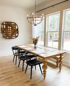 a dining room table with four chairs and a chandelier hanging from the ceiling