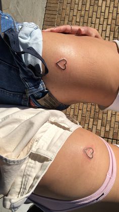 two people with small tattoos on their legs, one is holding the other's leg