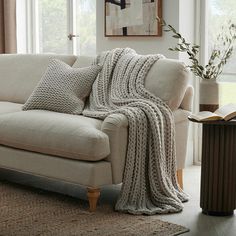 a couch with a blanket on it next to a window