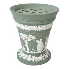 a green planter with white designs on it