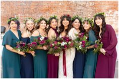 a group of women standing next to each other holding bouquets in their hands and smiling at the camera