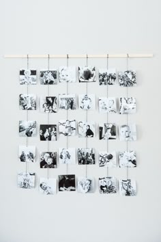 a white wall with pictures hanging from it's sides and clothes pins attached to them