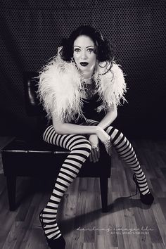 a woman sitting on top of a chair wearing striped stockings