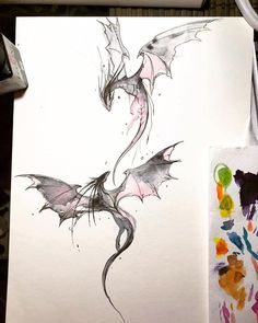 a drawing of a dragon on paper with watercolors