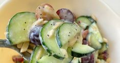 a salad with cucumbers, grapes and dressing