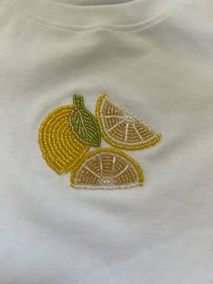 a white t - shirt with lemons embroidered on it