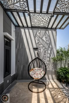 an outdoor area with a hanging chair and potted plants