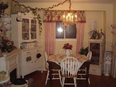 a dining room table with chairs and a chandelier hanging from it's ceiling