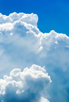 an airplane is flying in the blue sky with clouds behind it and one plane on the ground