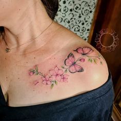 a woman's shoulder with pink flowers and butterflies on her left shoulder, while the upper half is covered in green leaves