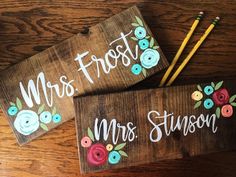 two wooden signs with flowers and the words mr and mrs written in white on them