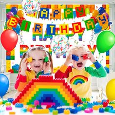 two children are playing with legos in front of a birthday banner and streamers