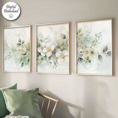 three floral paintings hang on the wall above a green chair