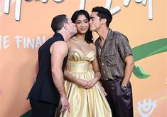 three people standing next to each other on a red carpet