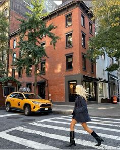 a woman crossing the street in front of a building