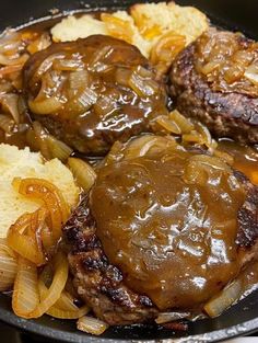 some meatballs and onions in a skillet with gravy on the side