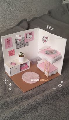 a hello kitty dollhouse with furniture and accessories in it's display case on a bed