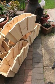 a wooden boat is sitting on the ground next to potted plants and other things