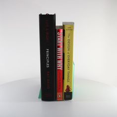 three books are stacked on top of each other in the shape of a bookend