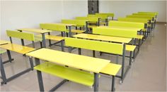 rows of yellow school desks in an empty classroom