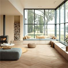 a living room filled with lots of windows next to a wooden floor covered in furniture